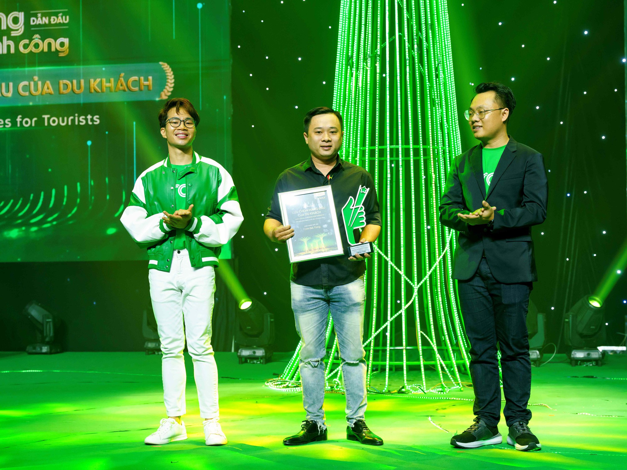 Anh Phan Duy Tùng (giữa) với thương hiệu Cơm gà Tùng được Grab vinh danh tại hạng mục &quot;Lựa chọn hàng đầu của du khách&quot;
